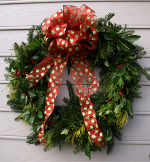 A wreath made of holly, Fraser fir, and gold mop cypress adds a traditional touch to an entry.