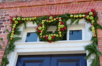 Fresh apples, nandina berries, and pine make a stunning arrangement around the entrance.