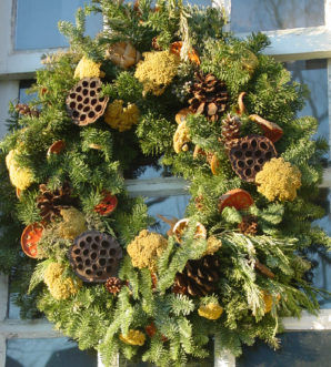 Lotus seed pods, dried yarrow and fruit, and pine cones adorn a Frasier fir wreath.