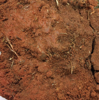 Clay soil particles are very fine and stacked together, similar to un-neatly stacked sheets of paper.