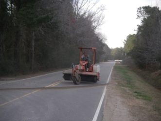 Sediment that was tracked on the roadway is being swept up to keep the roadway clear. Photo by Chuck Jarman, Clemson Extension.