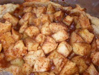 Apple pie filling in the pie crust ready for the oven.