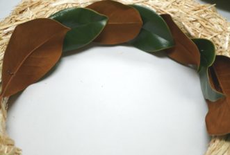 Alternate the top and backside of the magnolia leaves and secure with fern pins on the inside of the wreath form.