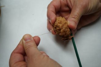 Wrap the wire of the floral pick around the decorative object in order to firmly secure it to the pick.