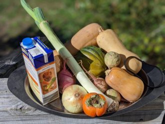 Black platter with ingredients for soup: chicken broth, butternut and acorn squash, onion, leek watermelon radish, and persimmon. Chase Baillie, ©2020, Clemson Extension