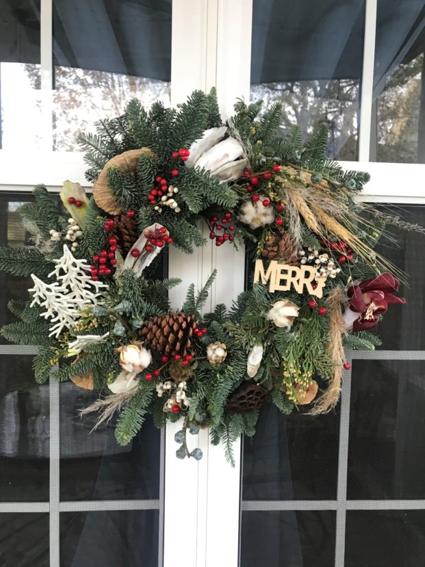 Live greenery wreath with dried flowers and ornaments.