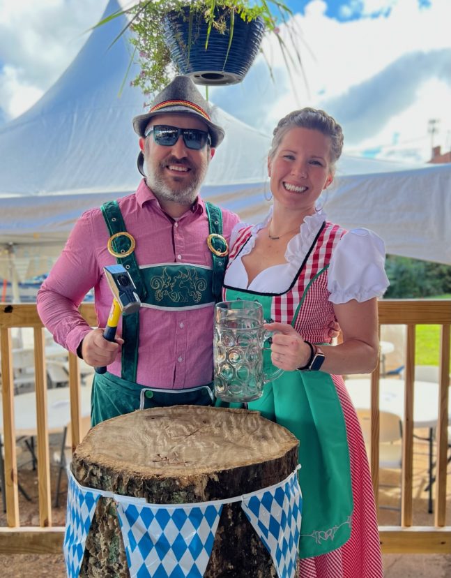 A man and woman wearing traditional German attire at Oktoberfest.