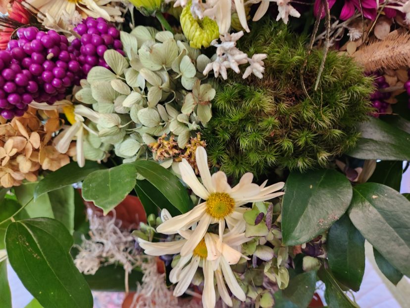A green moss ball adds a depth of texture to a floral arrangement.