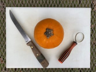 An orange on a cutting board Description automatically generated with low confidence