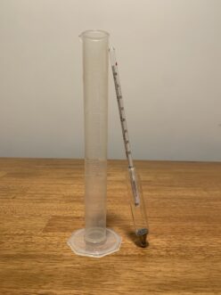 A hydrometer and graduated cylinder for testing.