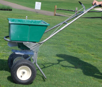 Fig. 9. Use a cyclone spreader to evenly broadcast the recommended fertilizer over the root zone area of shrubs and trees.