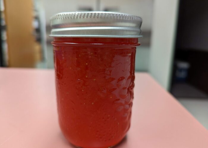 Processed strawberry lemonade concentrate in a ½ pint mason jar.