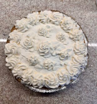 A pie with whipped cream icing.