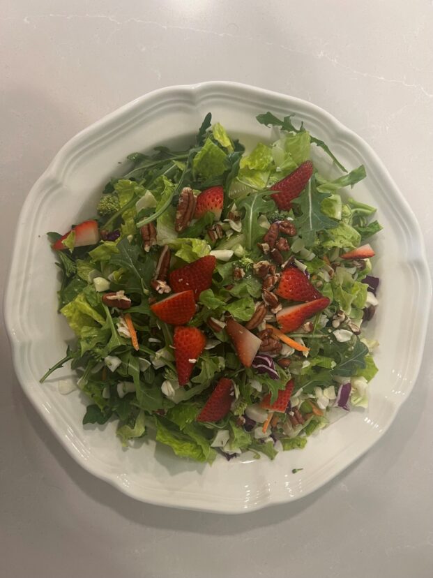 A leafy green salad on a white plate.
