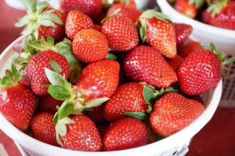 “Freshly picked ripe strawberries collected in a shallow basket.”