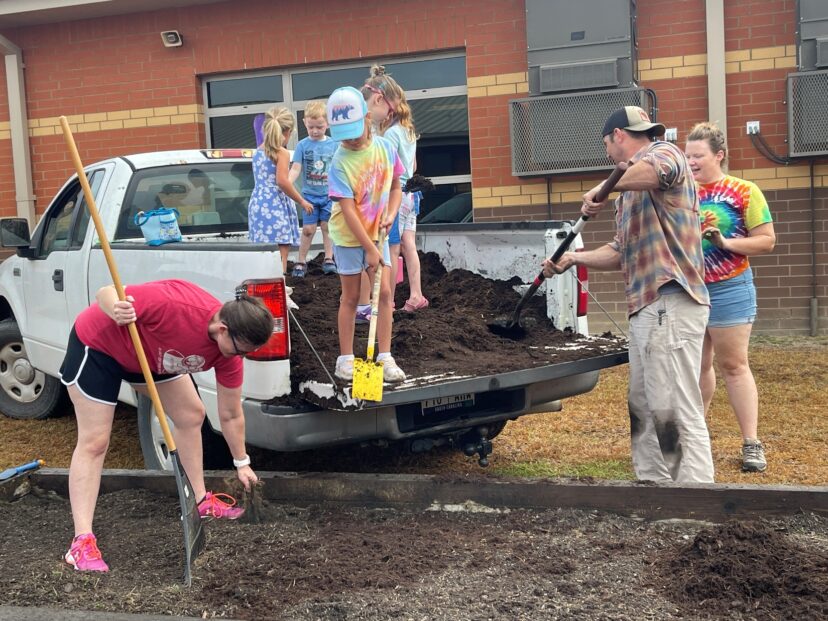 A group of people digging in the back of a truck AI-generated content may be incorrect.