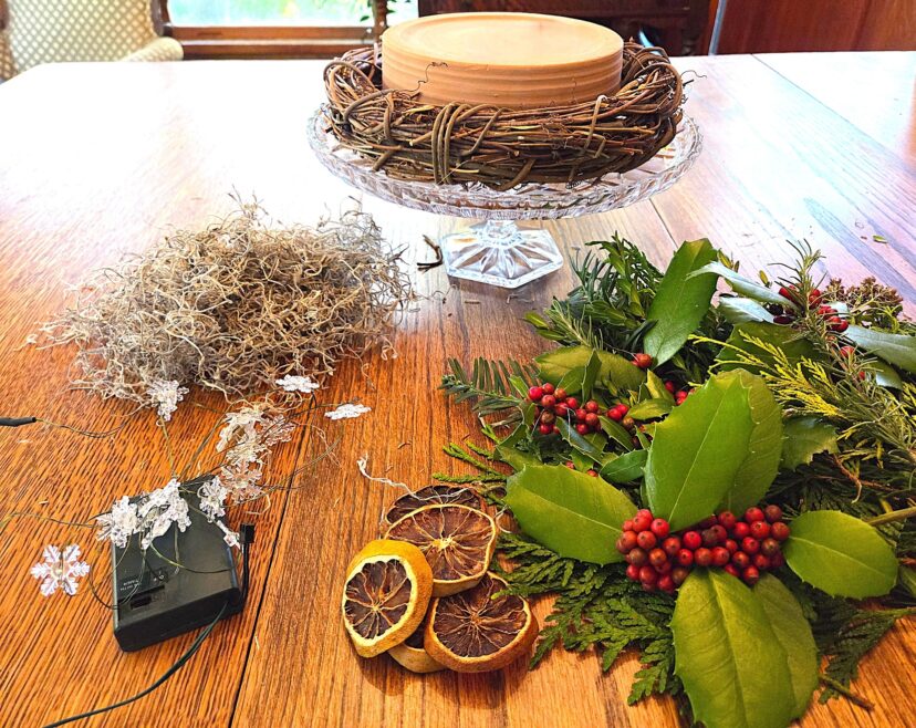 “Assortment of fresh greenery, berries, and natural elements displayed for holiday decorating.”