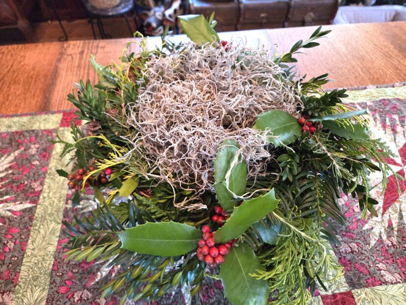 “Spanish moss layered around a support container to hide its edges on a pedestal arrangement.”