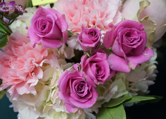 “Close‑up of pink roses and carnations paired with white hydrangeas, creating a fresh, refined bouquet.”