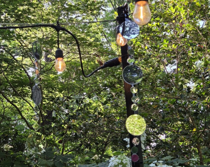 Mirrored garden ornaments reflecting sunlight throughout the flower garden.