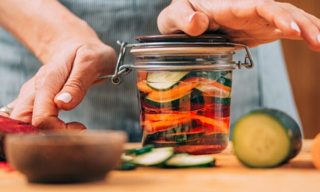 A woman holding a jar with fermented vegetables