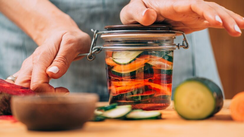 A woman holding a jar with fermented vegetables