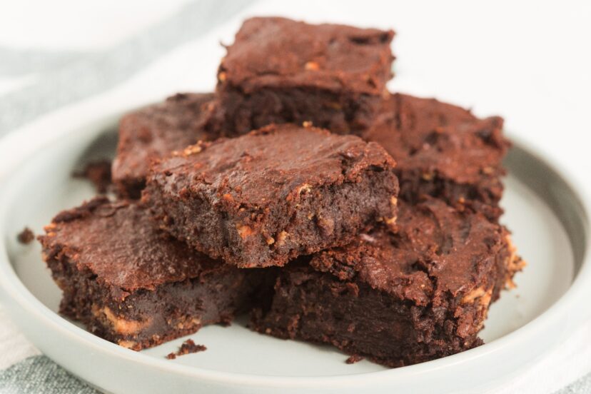 Stack of chocolate brownies on a white plate.