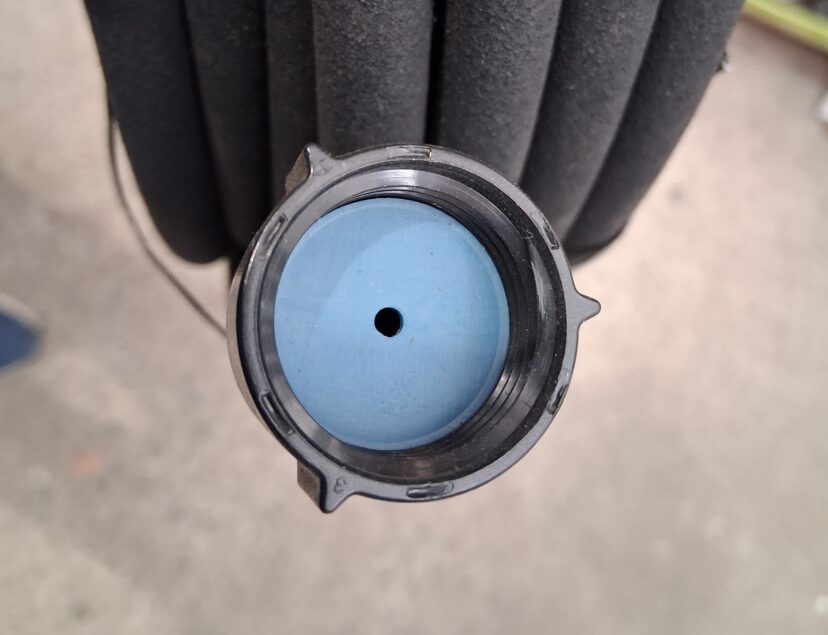 Close-up of the flow-restrictor plate inside a soaker hose connection.
